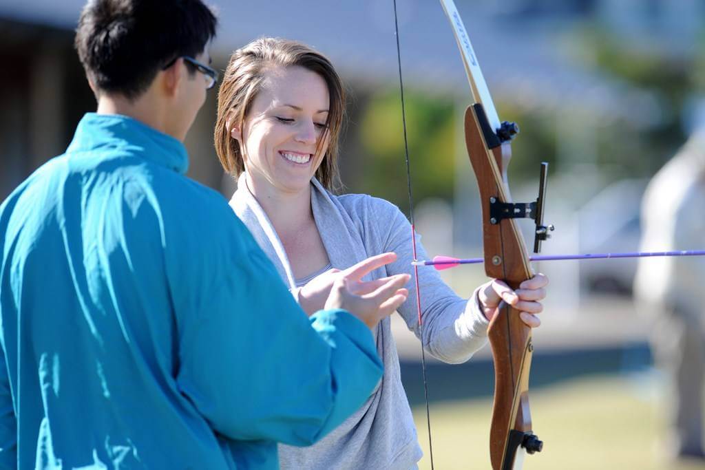 Woman getting private coaching for archery