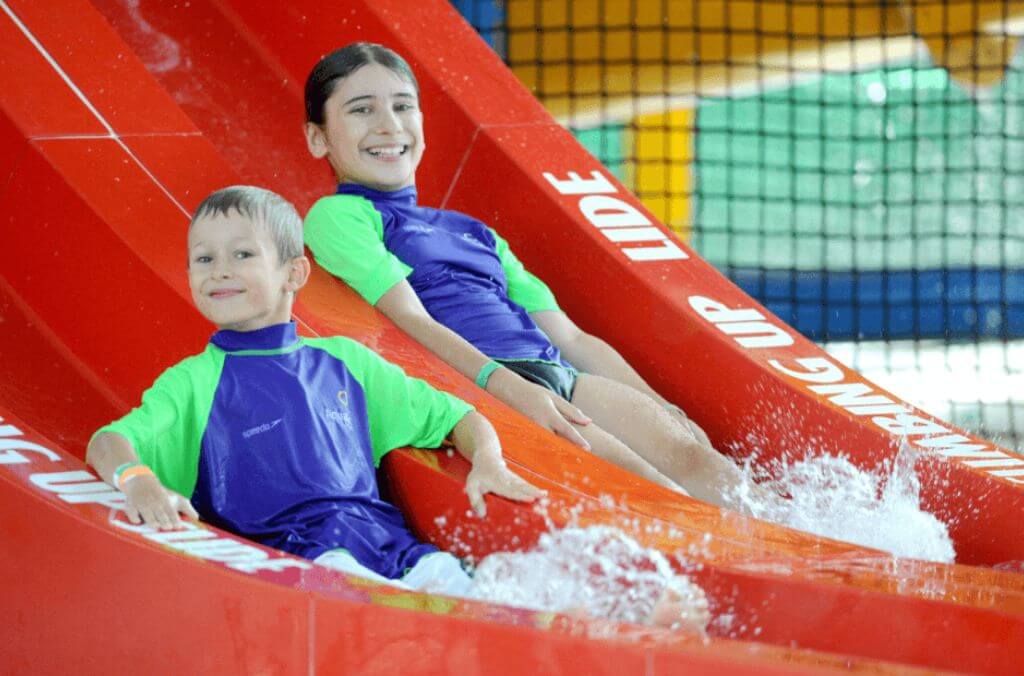Image of two kids riding down a water slide