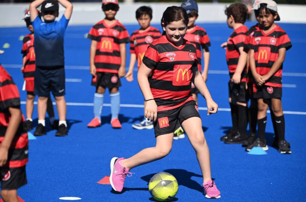 Image of kids playing soccer wearing the Western Sydney Wanderes uniform