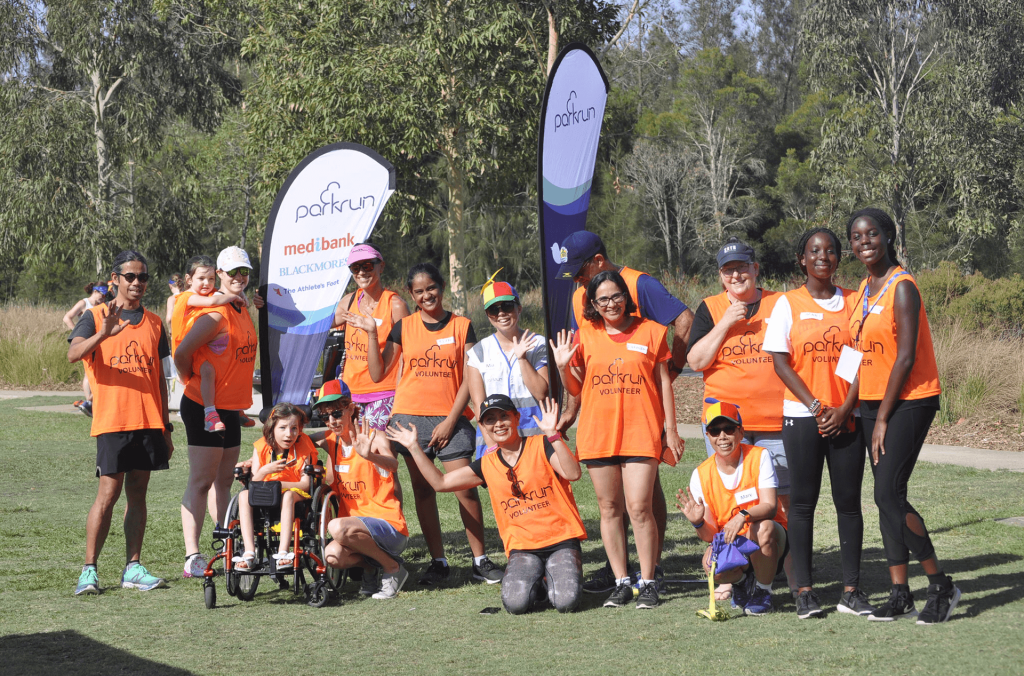 Many people in parkrun vests posing for photo